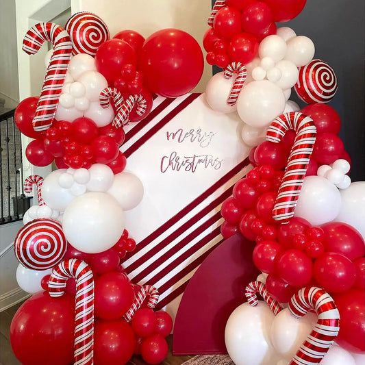 Christmas-themed balloon arch with red, white, and candy cane decorations.