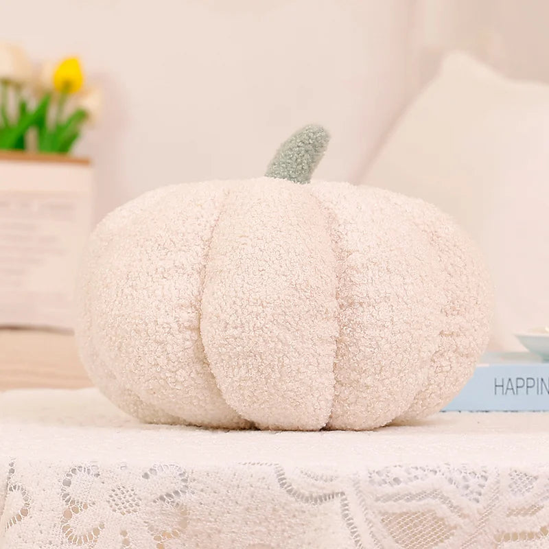 White pumpkin-shaped pillow on a surface with a blurred background