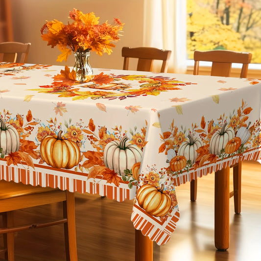 Dining table set with a fall-themed tablecloth featuring pumpkins and leaves, accompanied by chairs.