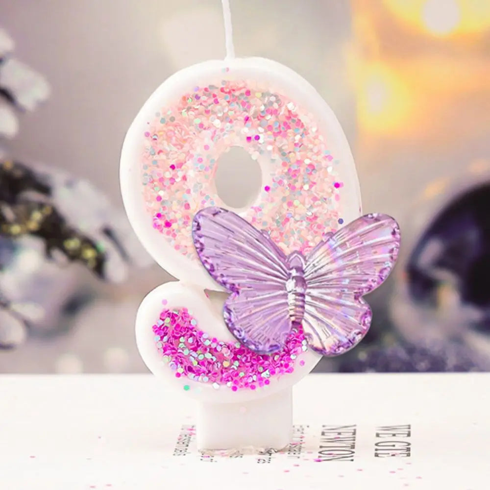 Decorative number '9' with a butterfly and pink glitter on a blurred background
