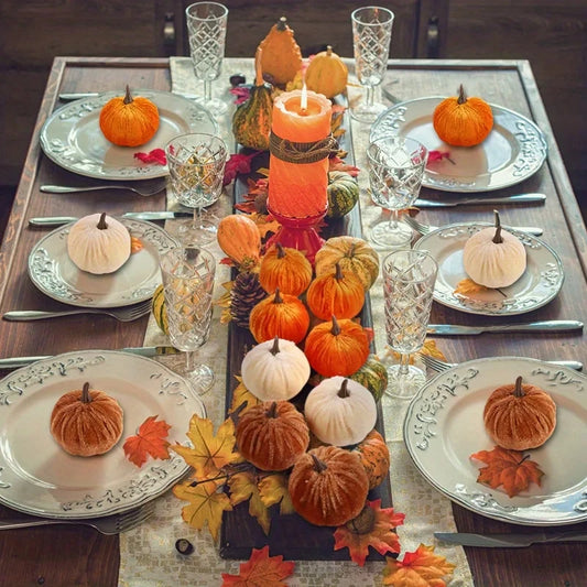 Decorative table setting with pumpkins and candles for a festive atmosphere.