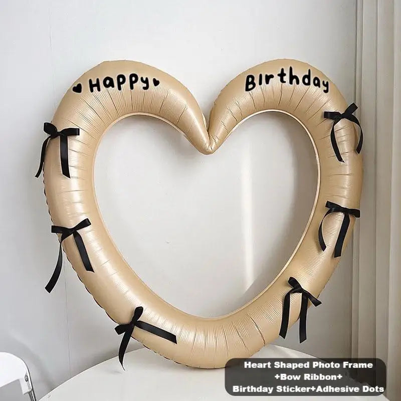 Heart-shaped photo frame with birthday stickers and ribbons on a white background