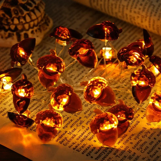 String of small pumpkin-shaped lights on a piece of paper with text.
