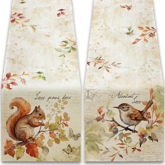 Two decorative towels with autumn-themed designs featuring a squirrel and a bird.