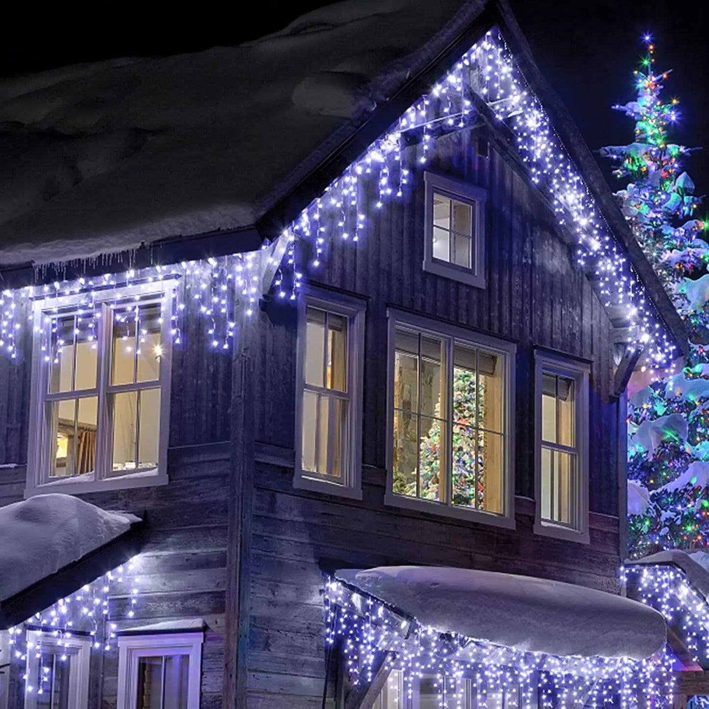 Wooden cabin decorated with string lights and a Christmas tree in the snow.