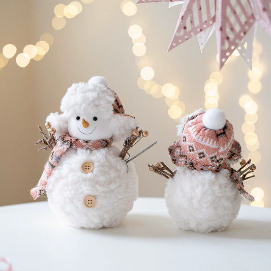 Two decorative snowmen with scarves and hats against a softly blurred background with lights.