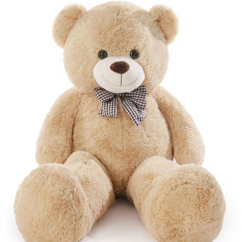Beige teddy bear with a checkered bow tie on a white background