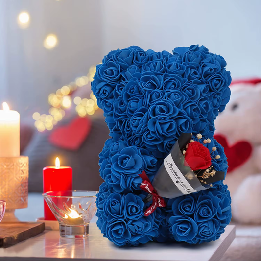 Blue rose teddy bear with a heart-shaped gift on a blurred romantic background