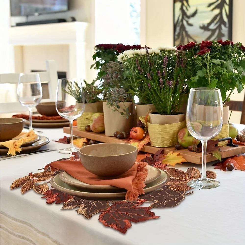 Decorative table setting with fall-themed elements including leaves, bowls, and wine glasses.