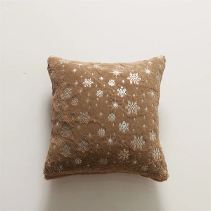 Brown pillow with snowflake pattern on a light gray background