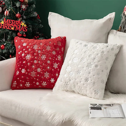 Decorative pillows on a couch with a Christmas tree in the background