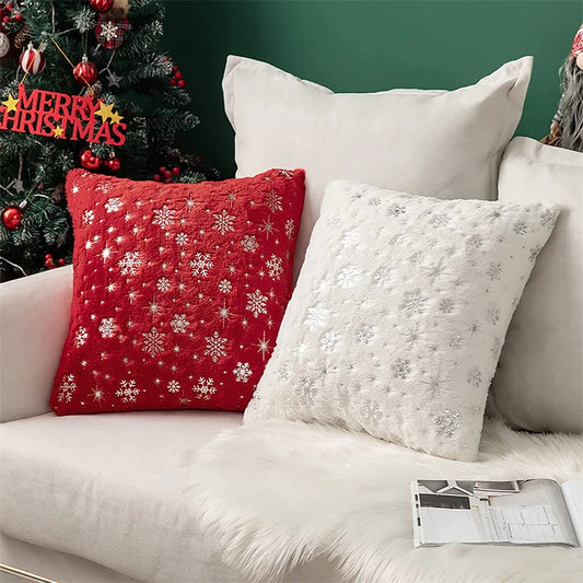 Decorative pillows on a couch with a Christmas tree in the background