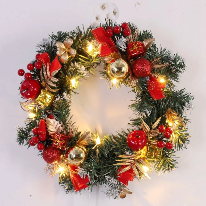 Decorative Christmas wreath with lights, red berries, and gold ornaments on a white background