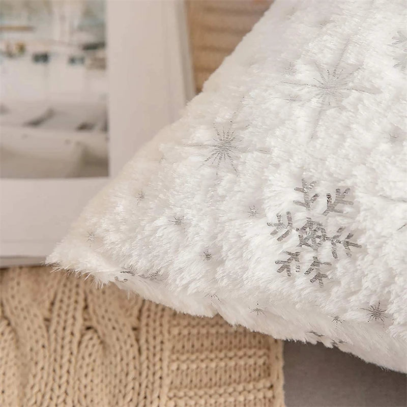White textured blanket with snowflake patterns on a blurred indoor background