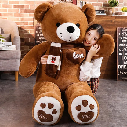 Large brown teddy bear with a girl hugging it in a cozy living room.
