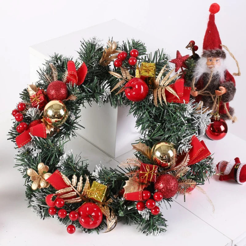 Decorative Christmas wreath with red berries, gold ornaments, and a small Santa figure on a white background.