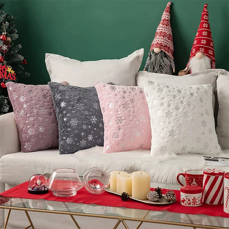 Decorative living room with Christmas-themed pillows, candles, and a small tree.