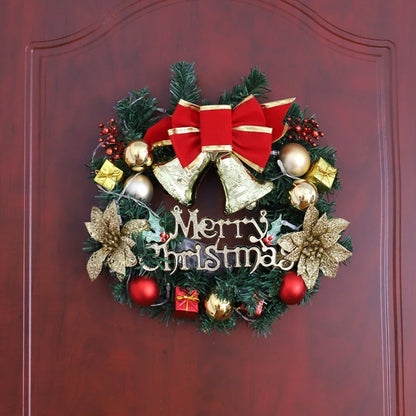 Decorative Christmas wreath with red bow, gold ornaments, and 'Merry Christmas' text on a wooden door.