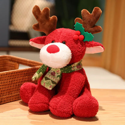 Red plush reindeer toy with a green scarf on a wooden surface.