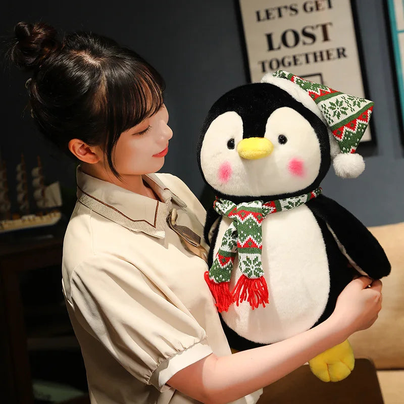Woman holding a plush penguin with a scarf and hat in a cozy indoor setting