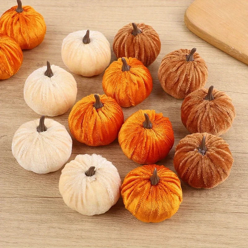 Small decorative pumpkins in orange and white on a wooden surface
