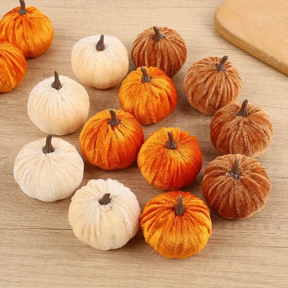 Small decorative pumpkins in orange and white on a wooden surface