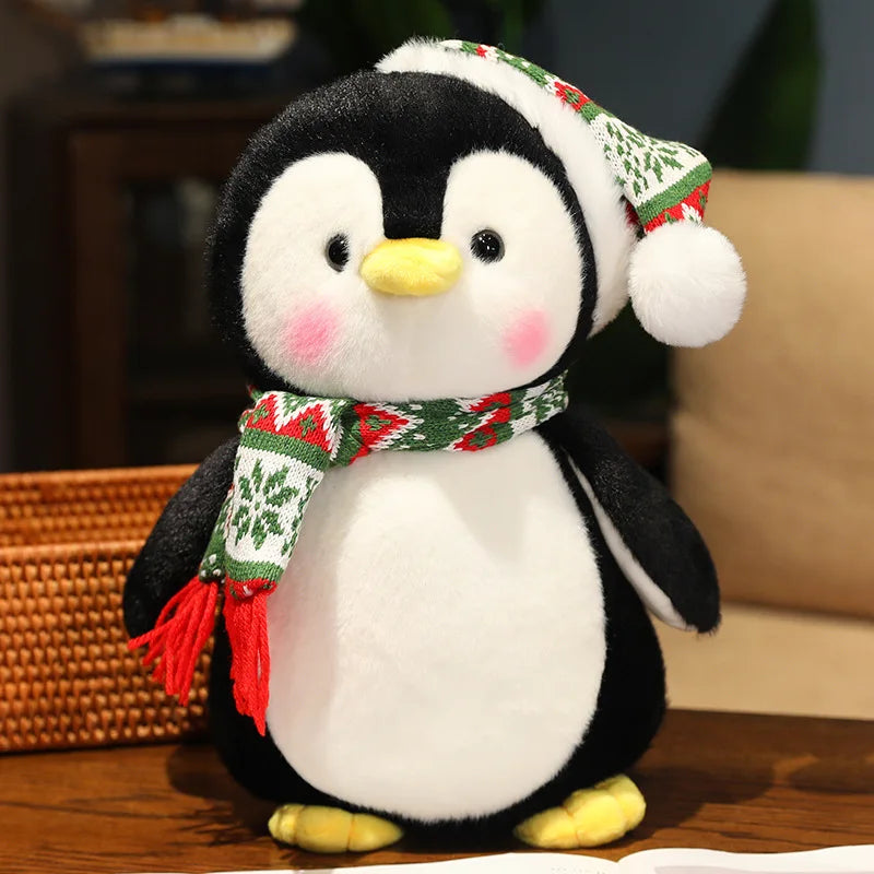 Plush penguin toy wearing a festive hat and scarf on a wooden surface.