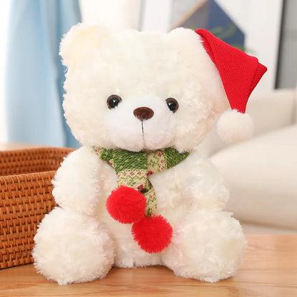 White teddy bear with a red hat and scarf on a wooden surface