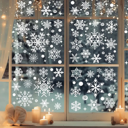 Decorative window stickers with snowflakes on a glass pane, with candles and decorative items on a table below.