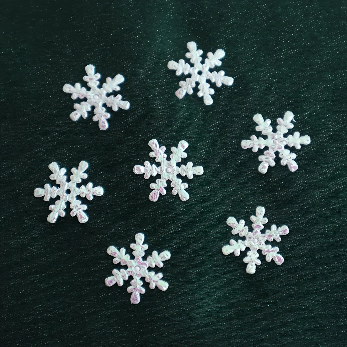White snowflake-shaped decorations on a dark green background