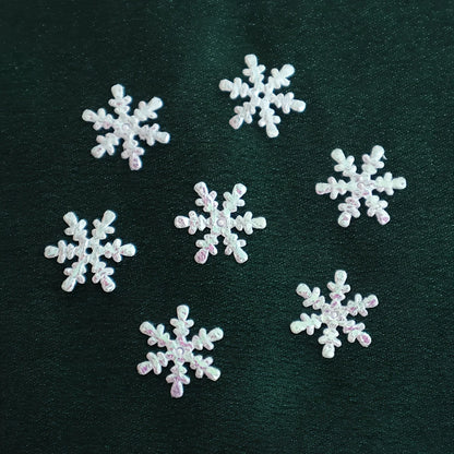 White snowflake-shaped decorations on a dark green background