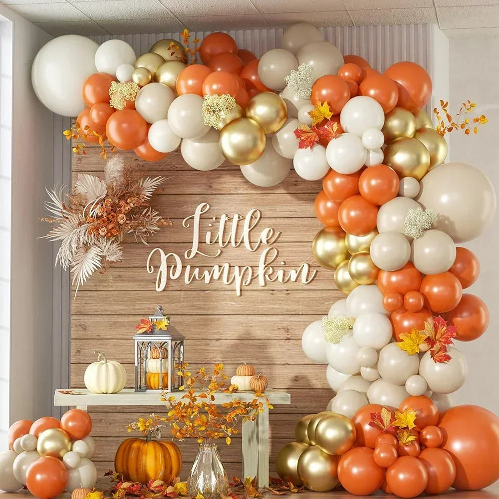 Decorative balloon arch with 'Little Pumpkin' sign and autumn-themed decor.