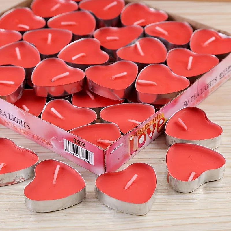 Heart-shaped red candles with a box labeled 'Romantic Love' on a wooden surface.