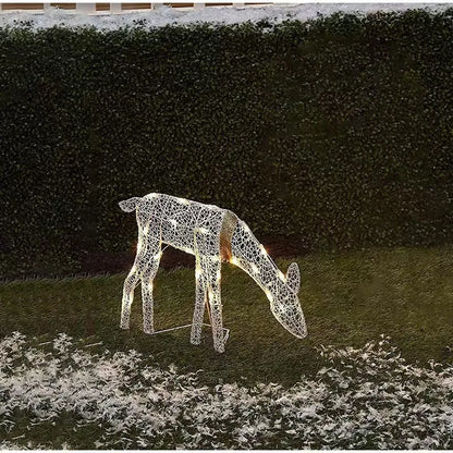 Decorative LED deer figure on grass with a hedge background