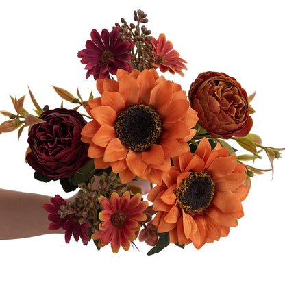 Bouquet of orange and red flowers held by a person on a white background