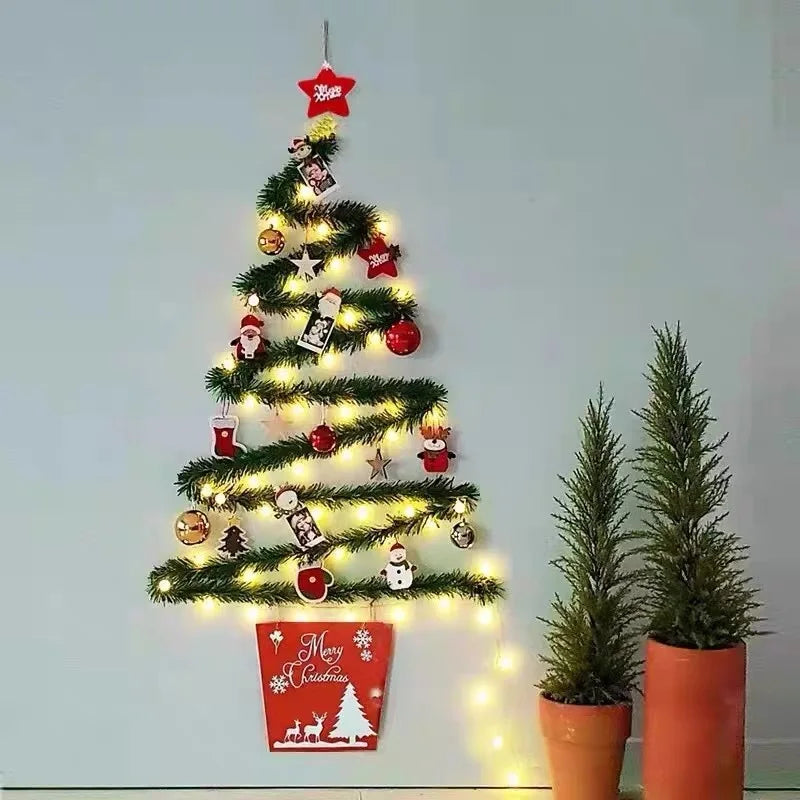 Wall-mounted Christmas tree with lights, ornaments, and a 'Merry Christmas' sign on a light blue wall.