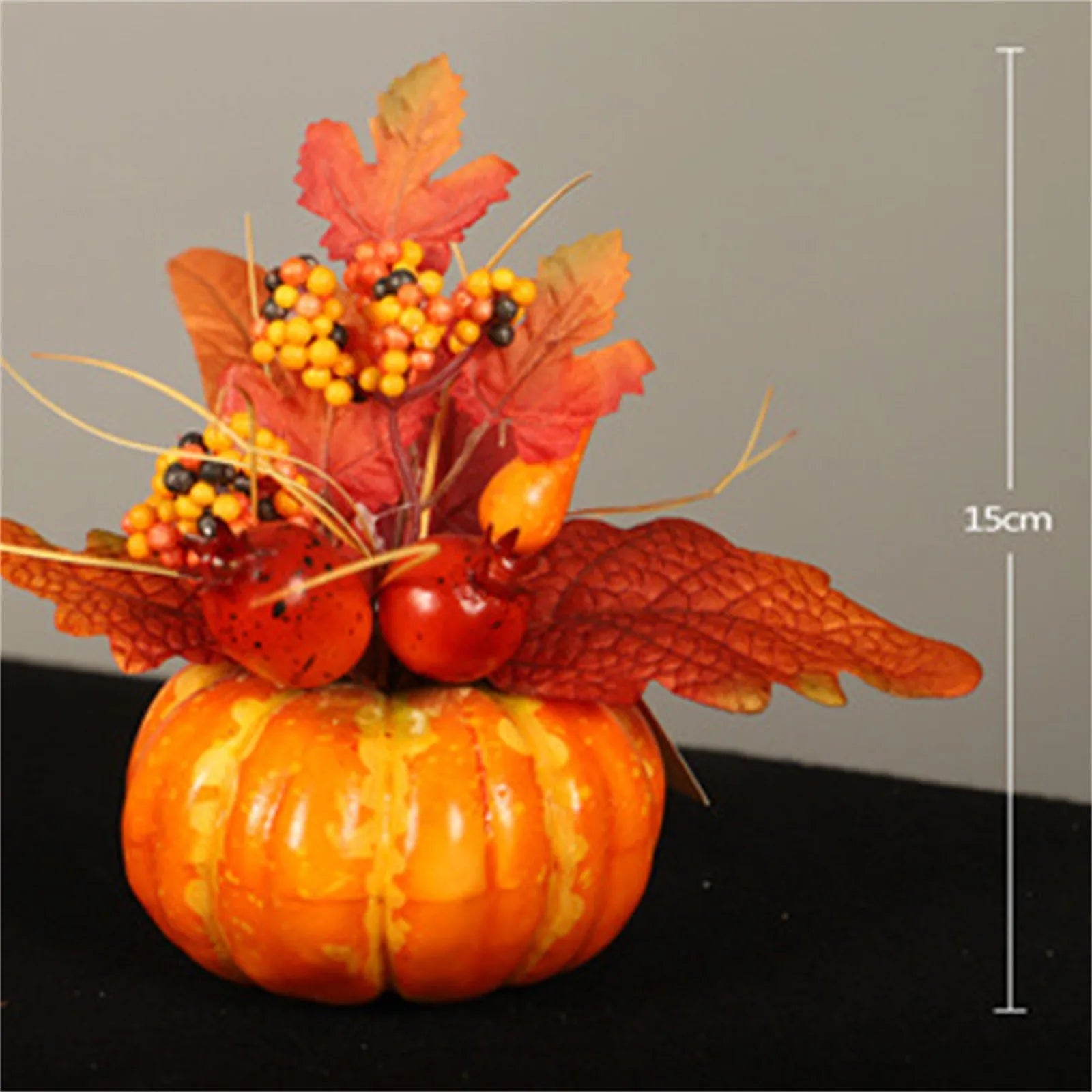Decorative pumpkin with autumn leaves and berries on a gray background with 15cm measurement
