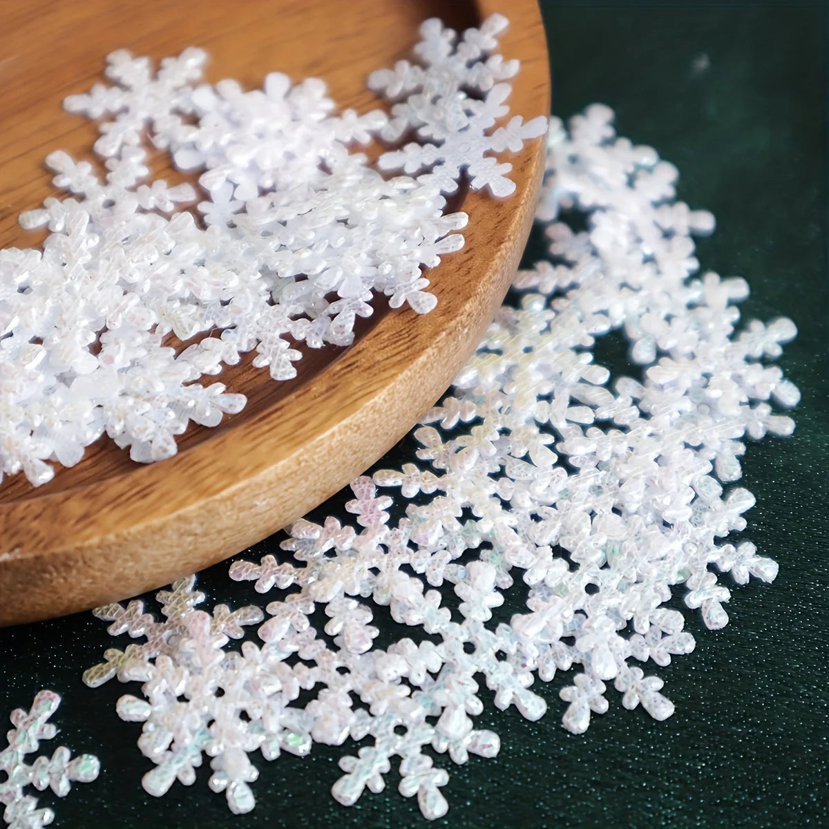 White decorative snowflakes on a wooden plate with a dark background