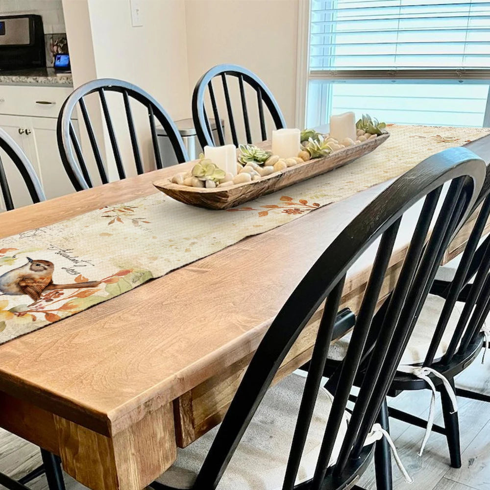 Dining room with a wooden table and black chairs, featuring a decorative centerpiece.