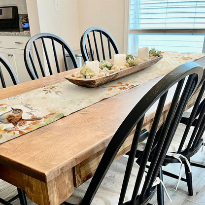 Dining room with a wooden table and black chairs, featuring a decorative centerpiece.