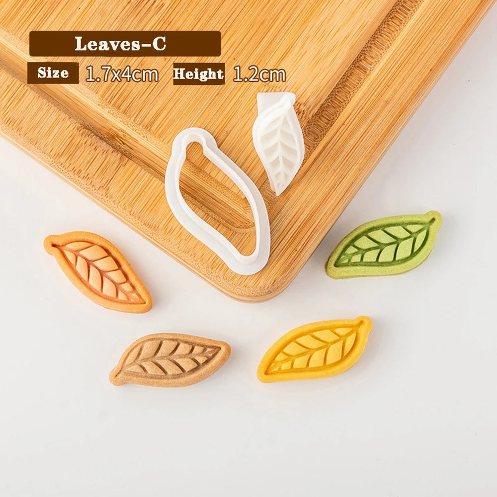 Leaf-shaped cookie cutters on a wooden board with measurements displayed.