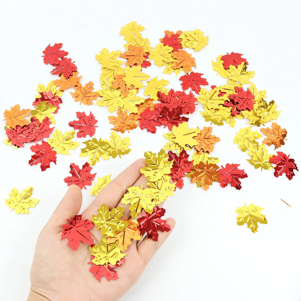 Colorful leaf-shaped confetti scattered on a white surface with a hand holding some.