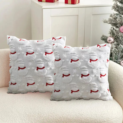 Two decorative pillows with red and white patterns on a beige couch.