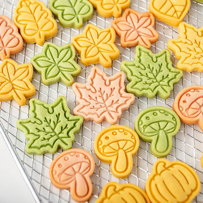 Colorful leaf and mushroom-shaped cookies on a cooling rack.