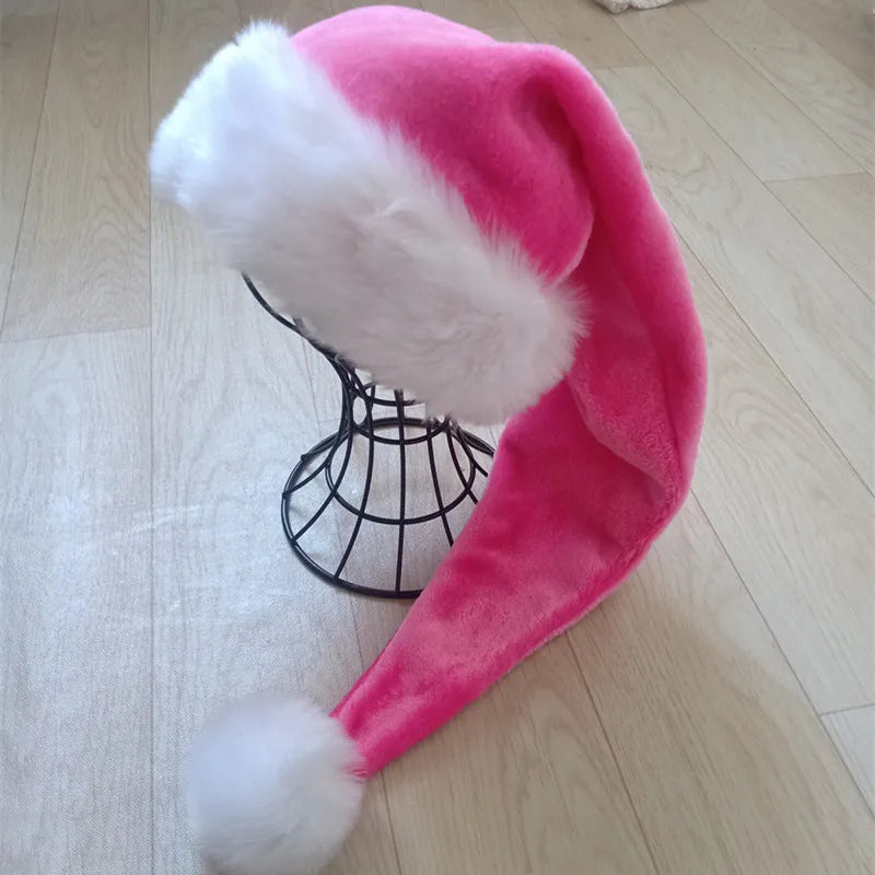 Pink Santa hat with white fur trim on a wooden floor
