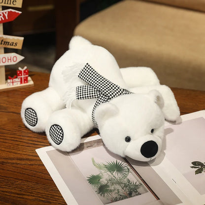 White teddy polar bear with a black bow tie on a wooden surface