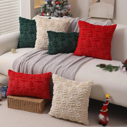 Decorative pillows on a couch with a Christmas tree in the background