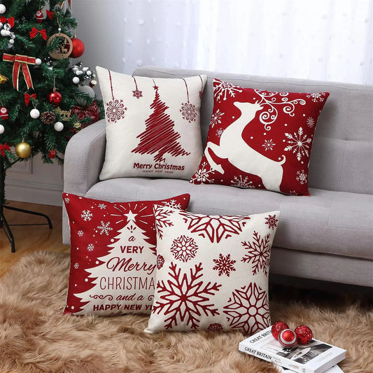 Decorative Christmas pillows on a couch with a Christmas tree in the background.