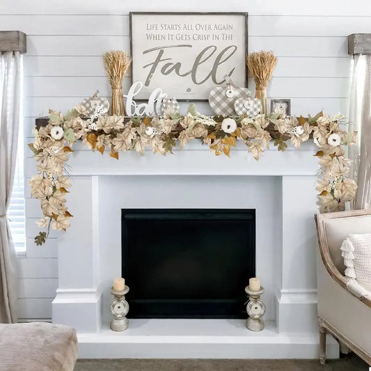 Decorative fireplace mantel with floral garland, candles, and a 'Fall' sign.