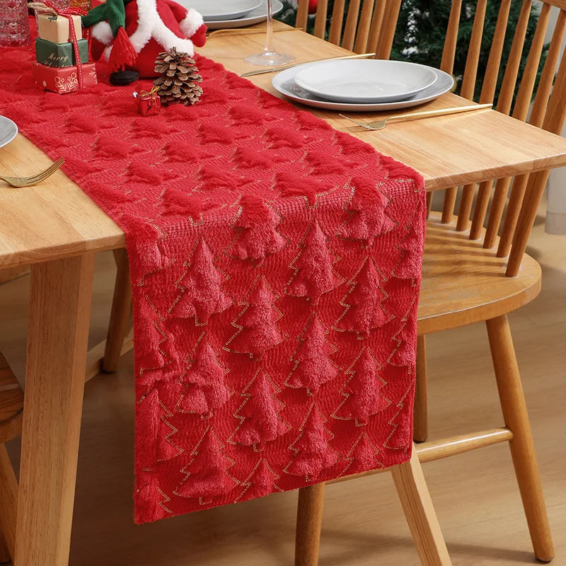 Red textured table runner on a wooden dining table with Christmas decorations.